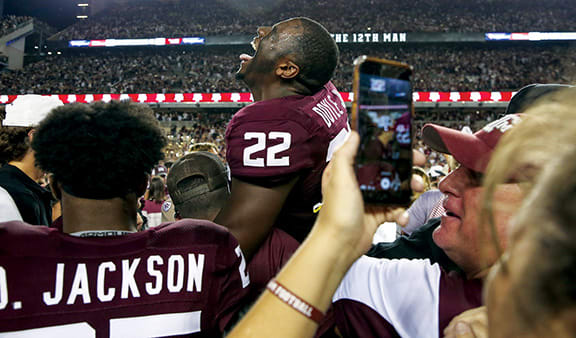 Texas A&M Aggies linebacker Antonio Doyle Jr. laughs as players and fans rush the field after beating Alabama at Kyle Field.